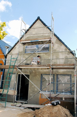 Verputzarbeiten an einem renovierten Holzhaus
