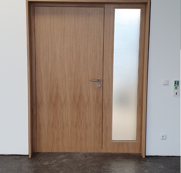 Innentür mit Holzoberfläche und einem schmalen verglasten Seitenteil.